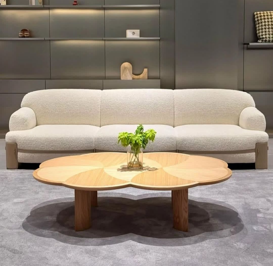 Ivory boucle sofa with a flower-shaped oak coffee table