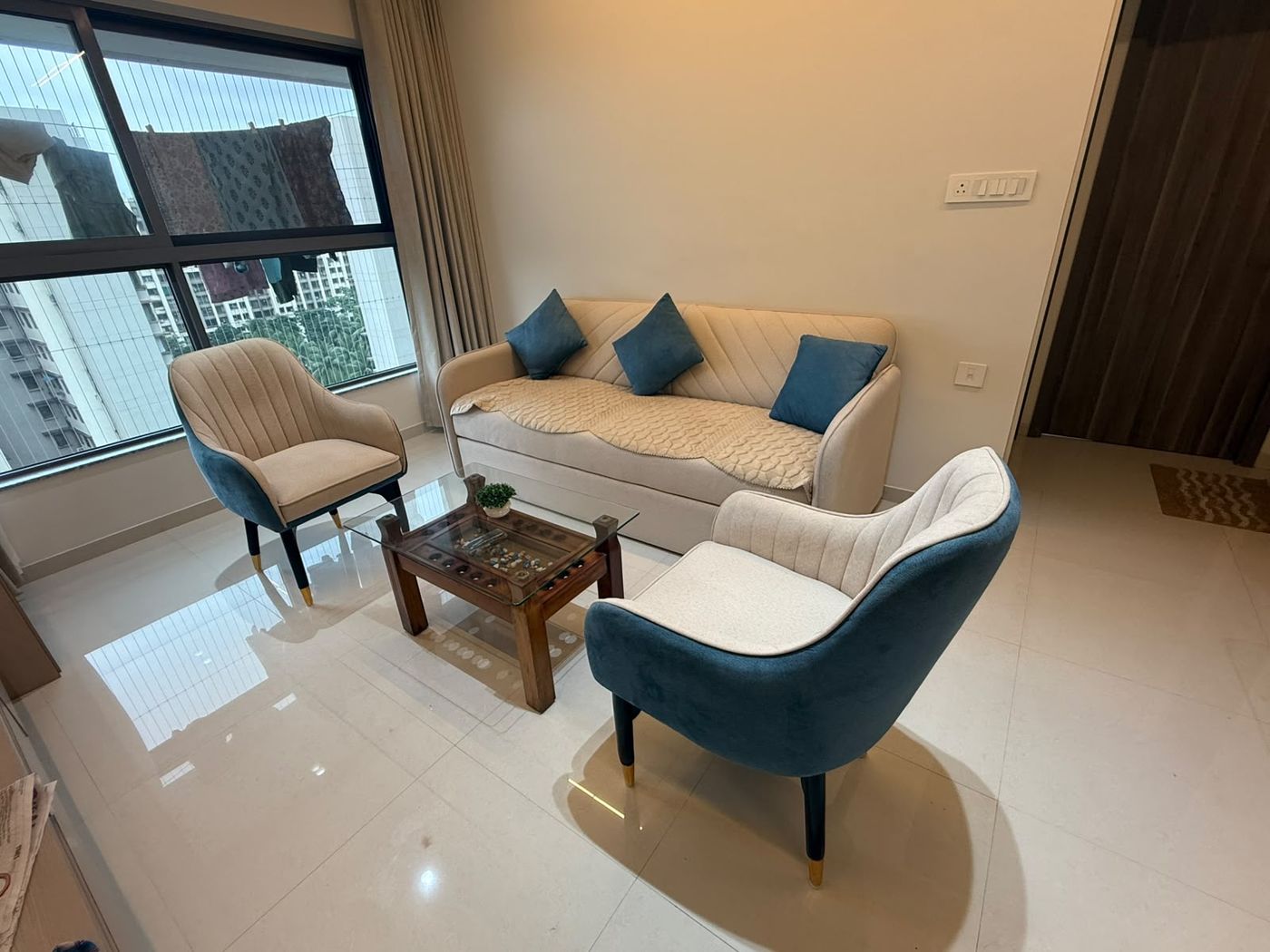 Sofa with teal and beige accent chairs