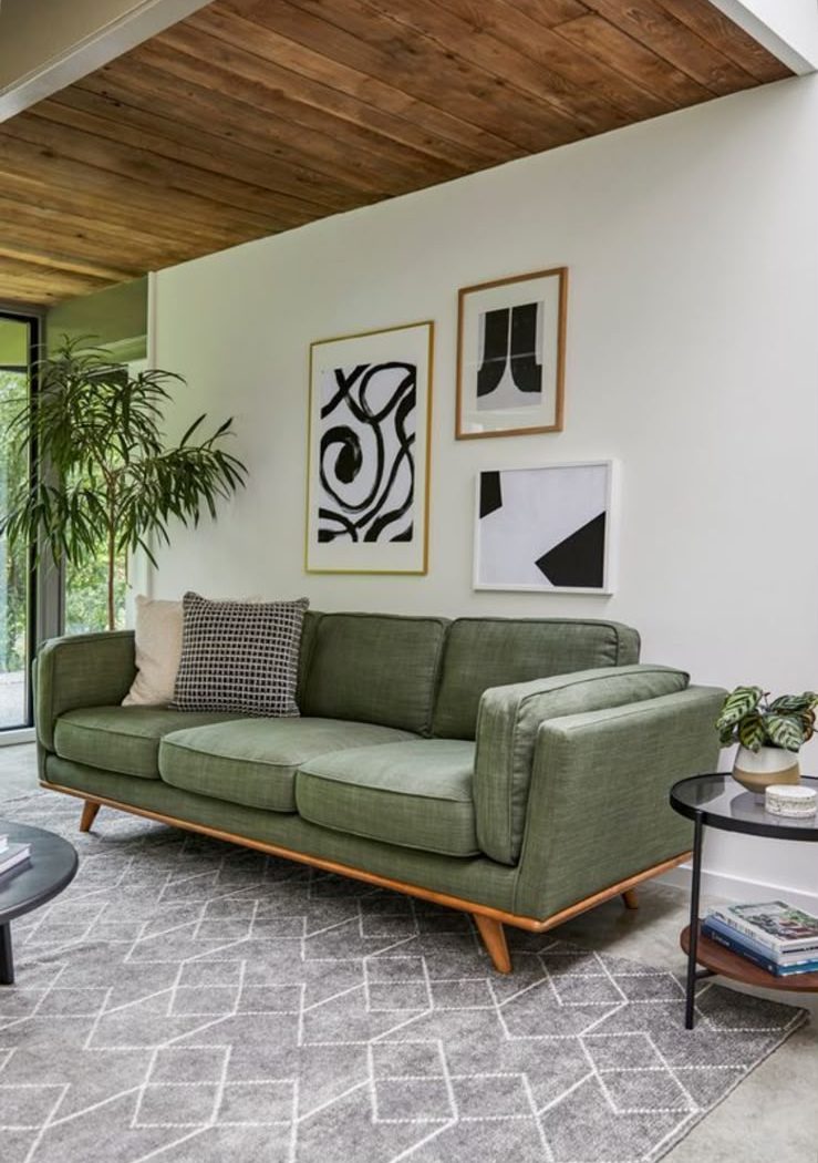 Sage green sofa on a wooden base