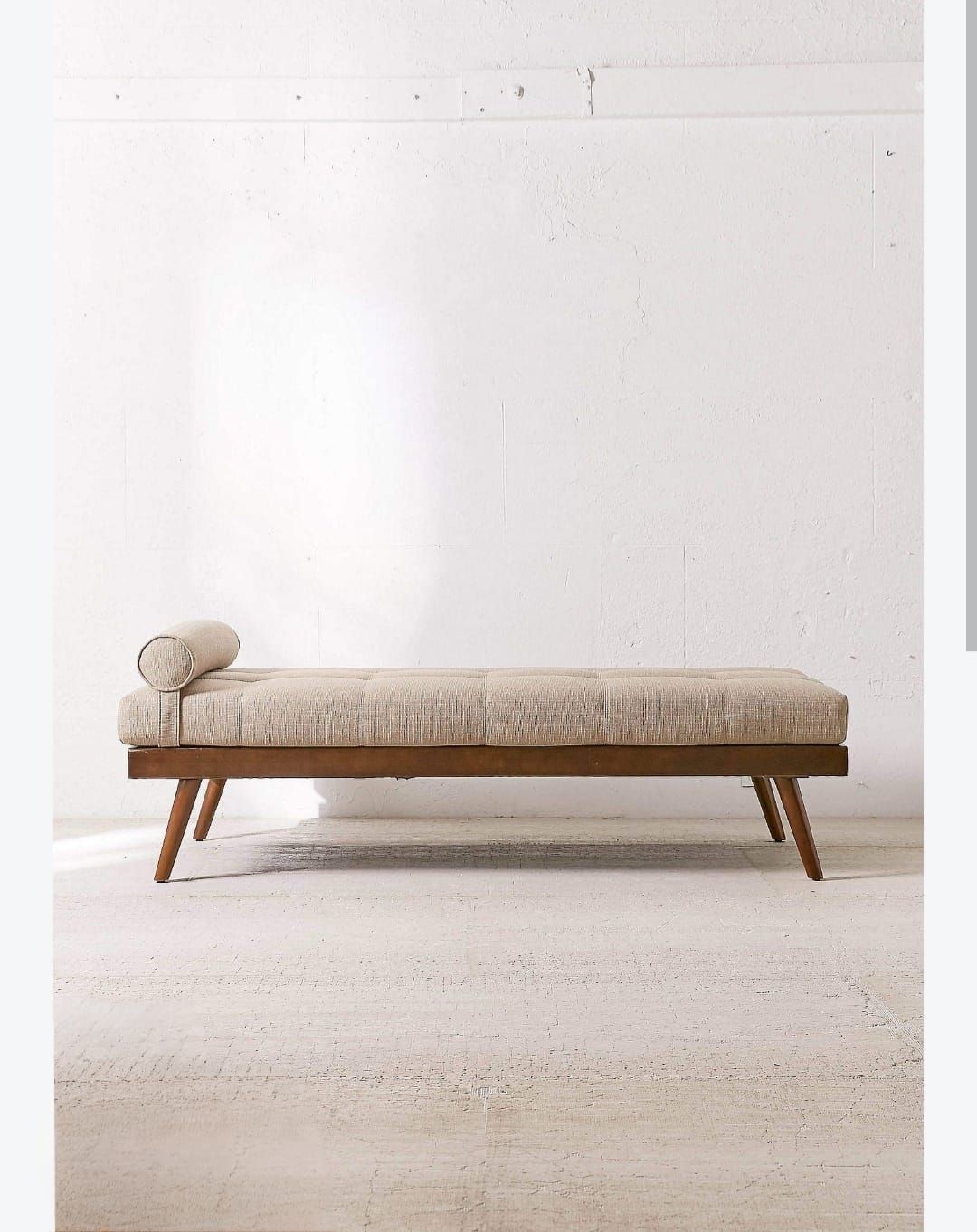 Upholstered daybed on tapered walnut legs